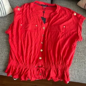 Really cute red top with a singe at the waistline. Tags on